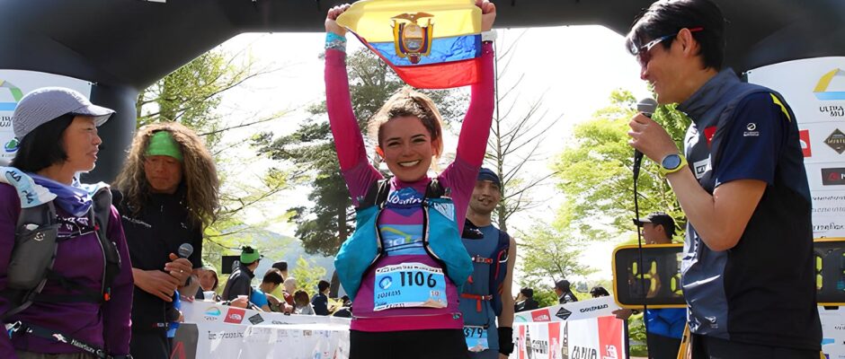 Mujer sostiene la bandera de Ecuador con felicidad en la meta de una carrera con logos de The North Face