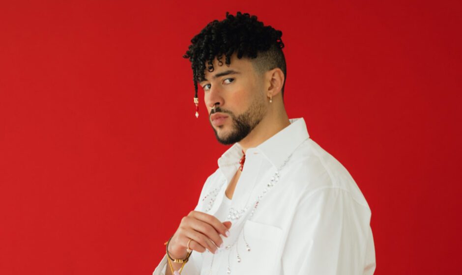 Foto de Bad Bunny posando con camisa blanca sobre fondo rojo