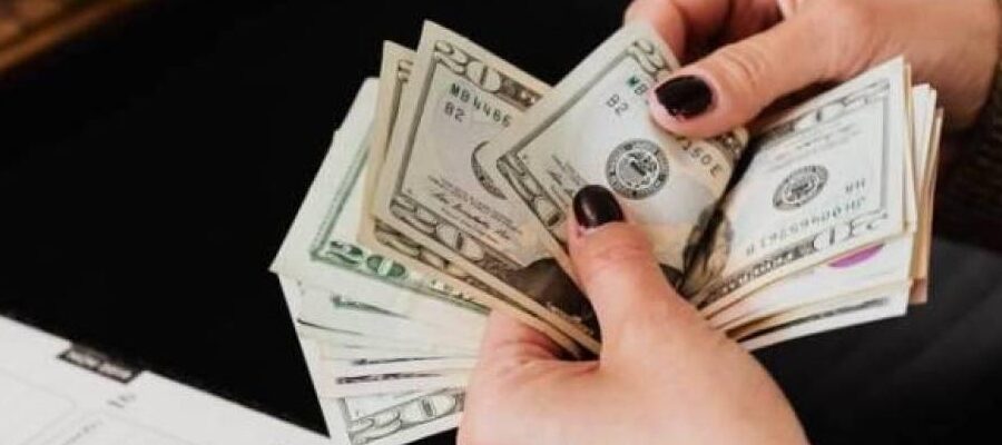 Persona contando billetes de 20 dólares